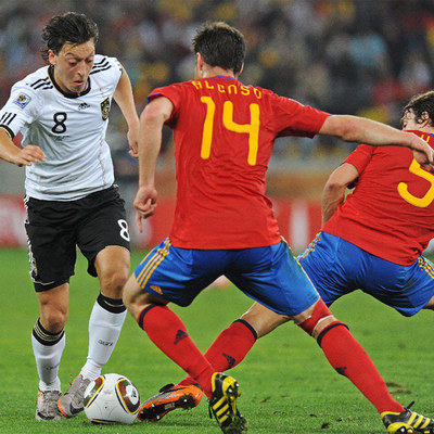 Özil trata de eludir a Alonso y Puyol durante el partido entre España y Alemania en el Mundial.