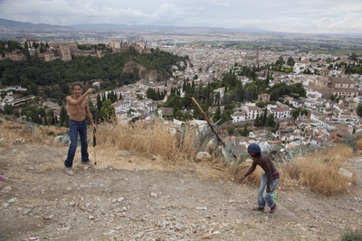 Dos jóvenes juegan en el lugar de Granada previsto para la construcción de un mirador  y donde habitan algunos vecinos en casas cueva.