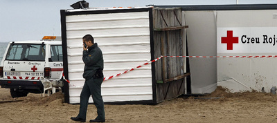 Un agente de la Guardia Civil junto a la caseta de la Cruz Roja derribada por el viento, que aplastó a un hombre en la playa de Burriana, ayer.