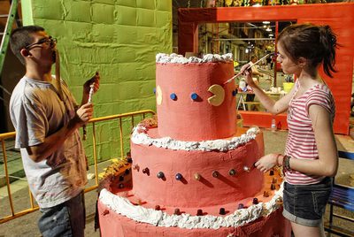 Unos jóvenes trabajan en la decoración de la calle Alcolea de Baix.