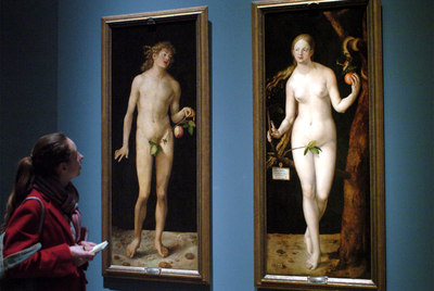 Una visitante, ante los cuadros  Adán  y  Eva  de Alberto Durero, en el Museo del Prado.