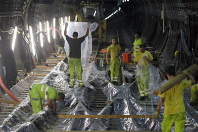 Arriba, los obreros colocan unas  chaquetas  para las vías justo debajo de la Castellana.