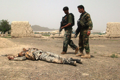 Dos soldados afganos junto al cadáver de uno de los asaltantes  talibanes, en la provincia de Khost.