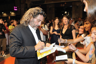 Ian McShane atiende a las fans durante su paseo por la alfombra naranja . 