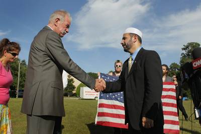 El pastor Jones da la mano al presidente de la Sociedad Islámica de Florida, Muhammad Musri, tras renunciar a la quema de coranes.