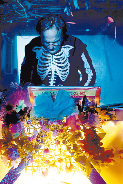  Dick El Demasiado, concentradísimo en su  laptop  en una actuación en Kioto, buscando un  hit  tropical con el que poner la pista a  culear.  