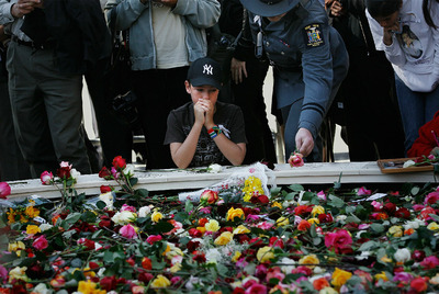 Un niño reza en la  zona cero,  en un lugar lleno de flores para homenajear a las víctimas de los atentados terroristas del 11 de septiembre de 2001.