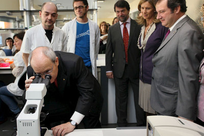 José Montilla mira por un microscopio. Detrás, Pedro Alonso, Cristina Garmedia y Jordi Hereu.