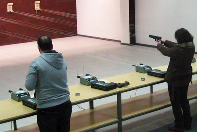 Dos trabajadores de Promoción Madrid compiten en una prueba de tiro pensada para mejorar su trabajo en equipo.
