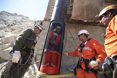 Trabajadores de los equipos de rescate prueban el lunes la cápsula en la que ascenderán a la superficie los mineros atrapados.