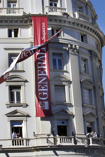 Un trabajador intenta amarrar el cartel del edificio Vitalicio, ayer por la mañana en Valencia.