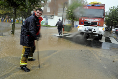 Varios bomberos achican agua de una calle inundada por el temporal en Vilagarcía de Arousa, Pontevedra.