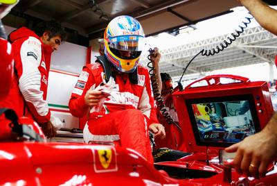 Los técnicos de Ferrari dan el último repaso al coche de Fernando Alonso en su presencia antes del Gran Premio de Brasil, el domingo.