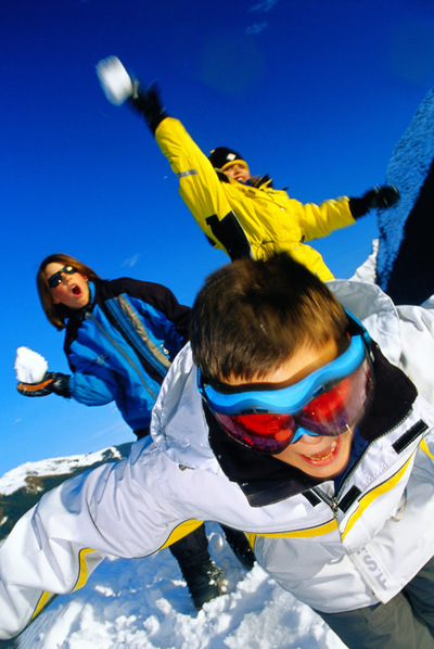 Un grupo de jóvenes se divierten tirándose bolas de nieve.