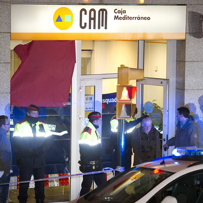 Pere Puig Puntí es sacado por los mossos d'esquadra de la sucursal de la Caja de Ahorros del Mediterráneo de Olot, el pasado miércoles.