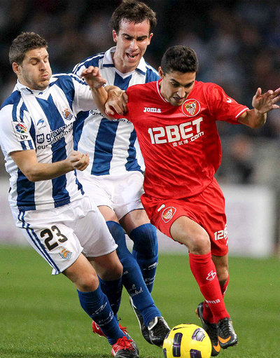 Navas conduce el balón presionado por Sutil y Elustondo.