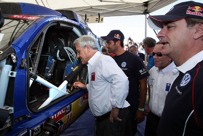 Sebastián Piñera, presidente de Chile, observa el Volkswagen Touareg junto a los dos pilotos de la marca, Al-Attiyah y Carlos Sainz.
