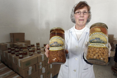 Una empleada de una de las empresas de agricultura orgánica muestra dos de sus productos.