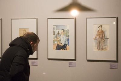 Un hombre observa varias de las piezas expuestas en la muestra.