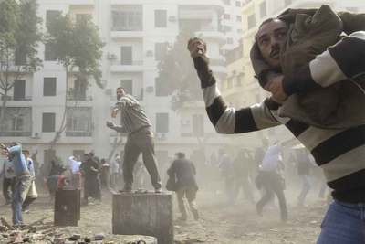 Opositores al régimen de Mubarak tiran piedras contra los grupos violentos leales al presidente en la plaza de la Liberación de El Cairo.