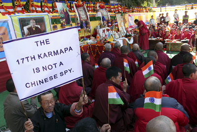 Exiliados tibetanos participan en una oración comunitaria en Nueva Delhi (India), en apoyo del Karmapa. En el cartel de la izquierda se puede leer: 'El decimoséptimo Karmapa no es un espía chino'.