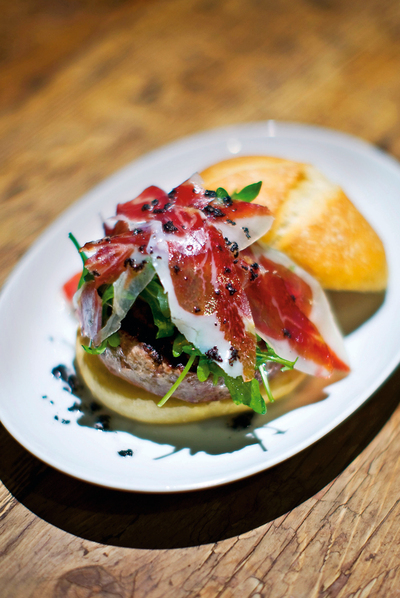 IbéricarnIngredientes: 150 gramos de ternera ecológica de cultivo biodinámico, pan elaborado a mano y con masa reposada de la panadería Baluard (Barcelona), crema de parmesano (crema de leche y queso parmesano), rúcula, jamón ibérico, aceite de trufa.rnElaboración: montar la hamburguesa sobre el pan y la rúcula, con una cucharada de la crema de parmesano. Colocar el jamón ibérico y aliñar con el aceite de trufa. Servir a caballo, sin montar la cubierta del panecillo.
