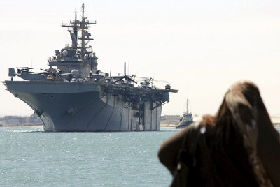 Una egipcia observa el paso por el canal de Suez del buque de guerra estadounidense  USS Kearsarge .