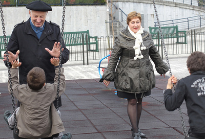 Javier Goñi y su esposa, Encarni Gutiérrez, juegan en un parque con dos niños a los que han acogido en su domicilio en Hondarribia.