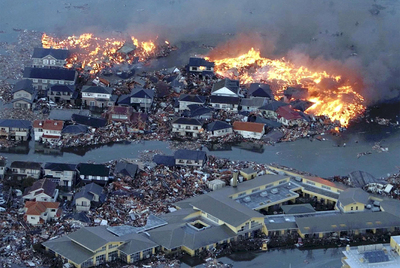 Viviendas en llamas y rodeadas de toneladas de escombros junto al río Natori, desbordado por las olas del tsunami, en la ciudad homónima.