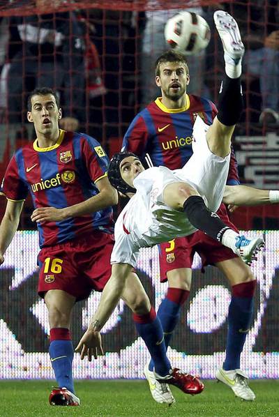 Negredo realiza un acrobático remate de chilena ante Busquets y Piqué.
