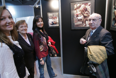 El fotógrafo Joan Colom paseando con su familia por la exposición  El color de Ciutat Vella. 