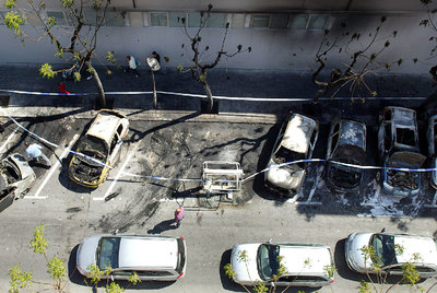 Varios coches calcinados en la madrugada de ayer son retirados de una calle de Tarragona.