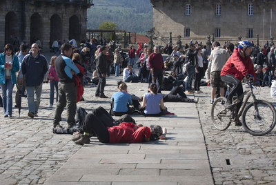 Turistas disfrutan del sol en la Praza do Obradoiro de Santiago.