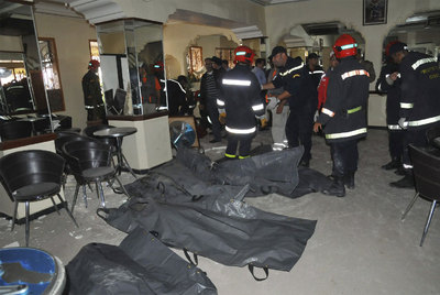 Miembros de los equipos de rescate, junto a los cuerpos de algunas víctimas mortales en el café Argana.