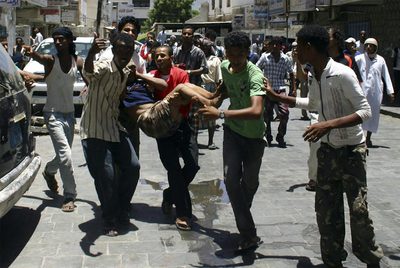 Manifestantes antigubernamentales trasladan a un herido durante los choques con la policía en Adén.