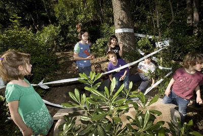 Los niños que han encontrado el rosetón enterrado juegan en la zona tras ser retirada la pieza para su estudio.