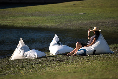 Una mujer descansa en un  puf  hecho con retazos de vela de barco.