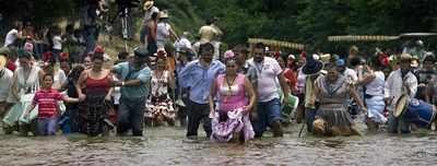 Miles de romeros cruzan el río Quema en su camino hacia El Rocío