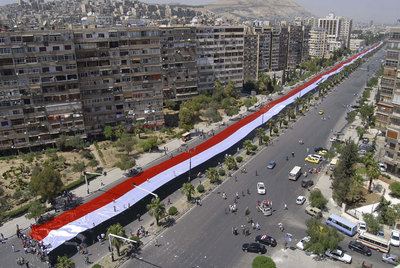Una bandera gigante en la manifestación de ayer a favor de El Asad en Damasco.