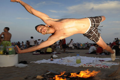 Un joven salta sobre una hoguera, anoche, en la playa de la Malva-rosa de Valencia.