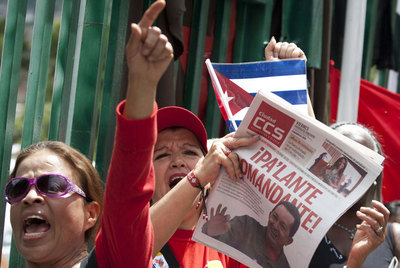 Un grupo de chavistas sale a la calle con banderas y un periódico con el lema 