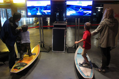 Dos niños juegan con el simulador de surf expuesto en la Alhóndiga.