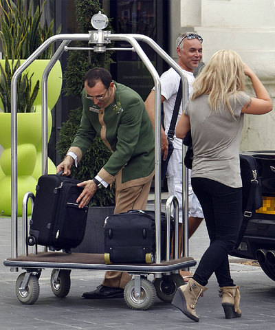 Un empleado carga el equipaje de dos turistas en un establecimiento hotelero de Valencia.