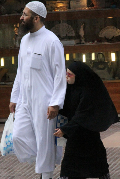 Un padre camina con su hija  por la avenida Juan Carlos I, en el centro de Melilla.