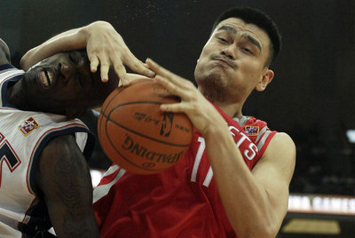 Yao Ming lucha por un rebote en un partido con los Houston Rockets.