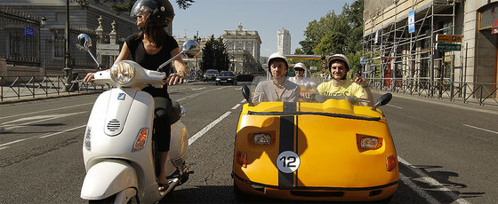 Turistas en un GoCar pasean por el centro de la ciudad mientras el coche les guía.