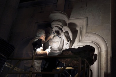 El escultor Jaume Casas da los últimos toques al dintel afectado por el incendio.