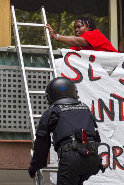 La inquilina desahuciada trata de impedir el accesso de un agente de los Mossos a su piso.