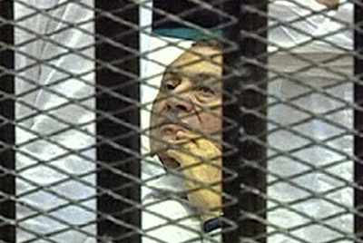 El expresidente egipcio Hosni Mubarak, en una camilla y tras las rejas, escucha los cargos en su contra.