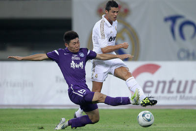 Cristiano dispara ante Bochao. Debajo, aficionados chinos con una pancarta de Mourinho y el lema: 